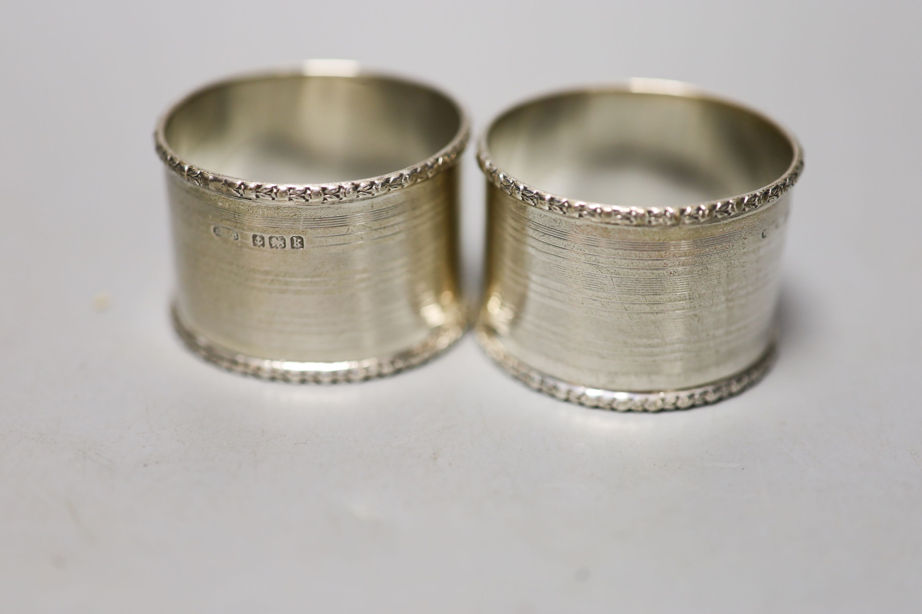 Four pairs of silver napkin rings including cased Victorian and a cased pair of silver pepperettes.